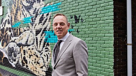 Burgemeester Ron König voor een muurschildering in Sluiswijk